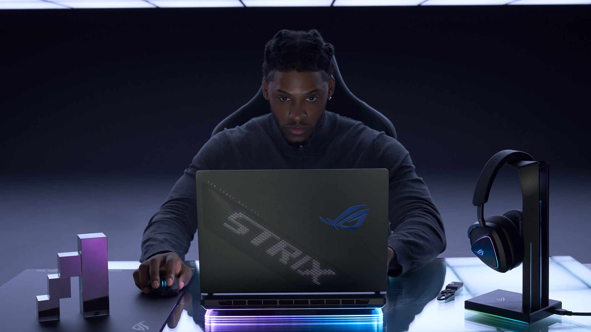 Мужчина смотрит на ноутбук ROG Strix SCAR, видна задняя часть крышки.
